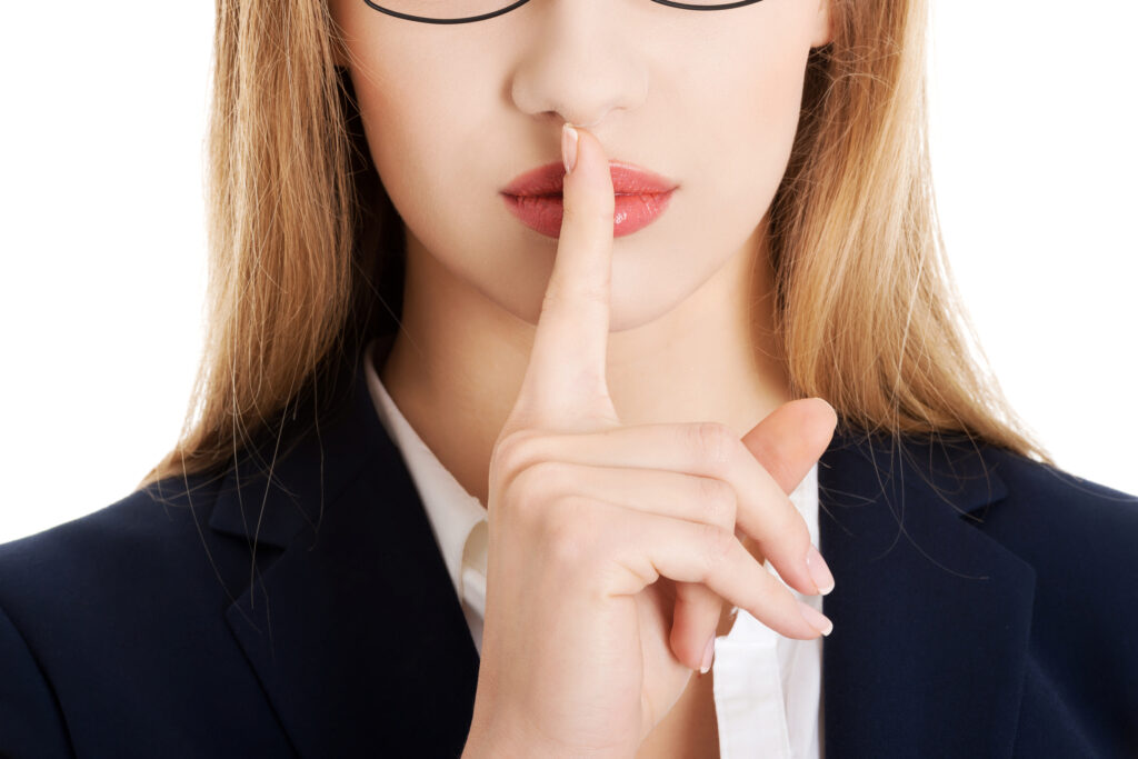Young businesswoman making silent gesture