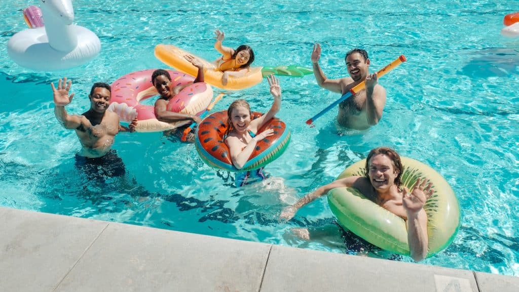 People swimming in pool with inflatables